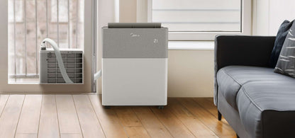 Air purifier in a modern living room with a couch and window.